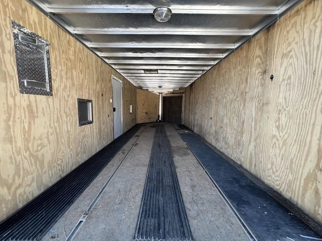 2008 Sno Pro 4-Place Snowmobile Trailer – Black Aluminum – Interior view looking toward the rear showing floor mats and walls