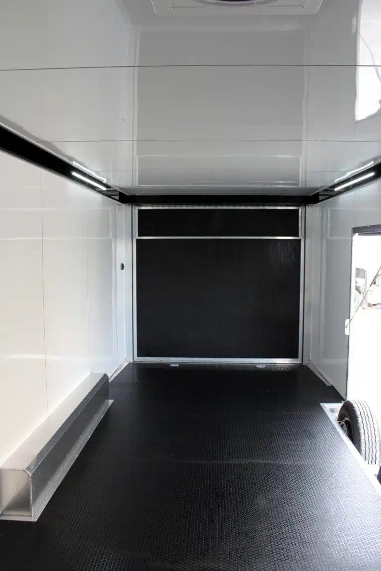 2026 ATC 24 ft Car Trailer – Silverfrost, Plus Package – Interior view facing the rear ramp door with black flooring