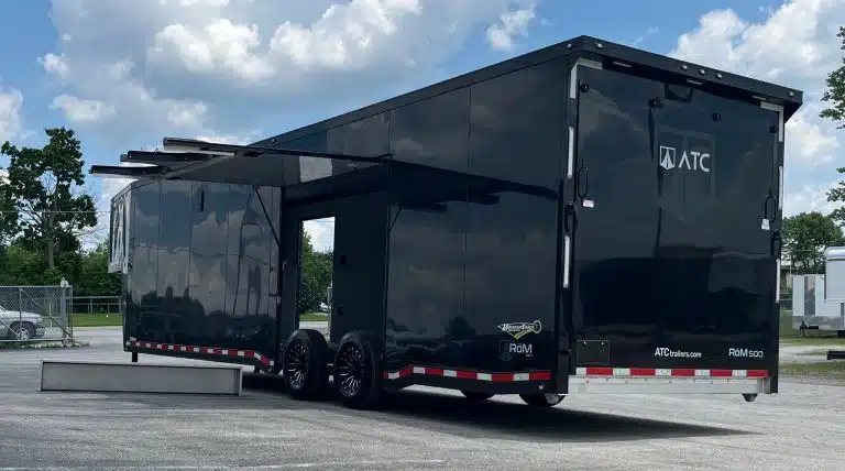 2026 ATC 40 ft Gooseneck – Black Trim – Full exterior view from the rear showing the side escape door open
