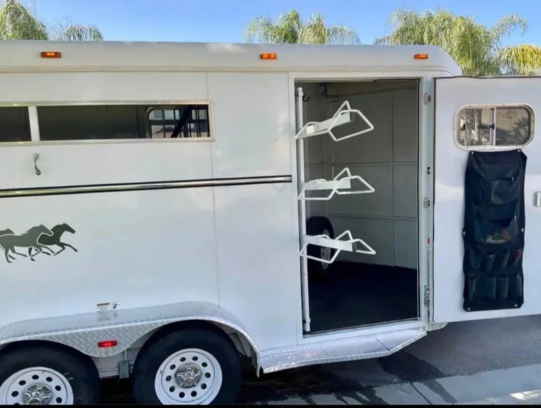 2007 Circle J 2 Horse Trailer – Slant Load – Side door open revealing the interior tack room and saddle racks