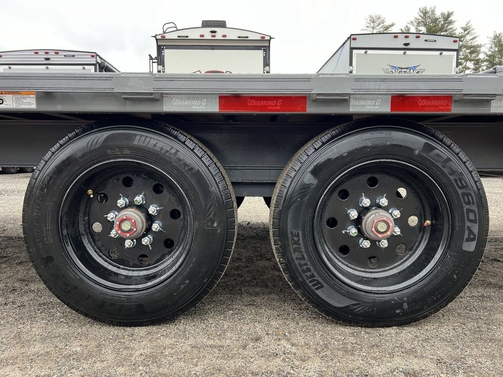 2024 Diamond C Deckover Equipment Trailer – Cement Gray – Close-up of the two black wheels and tires with red center caps