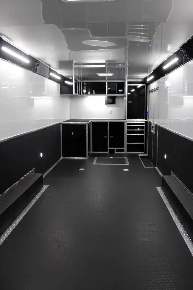 2025 Haulmark Edge 28 ft Enclosed Car Trailer – White – Interior shot showing black cabinets and storage area at the front of trailer