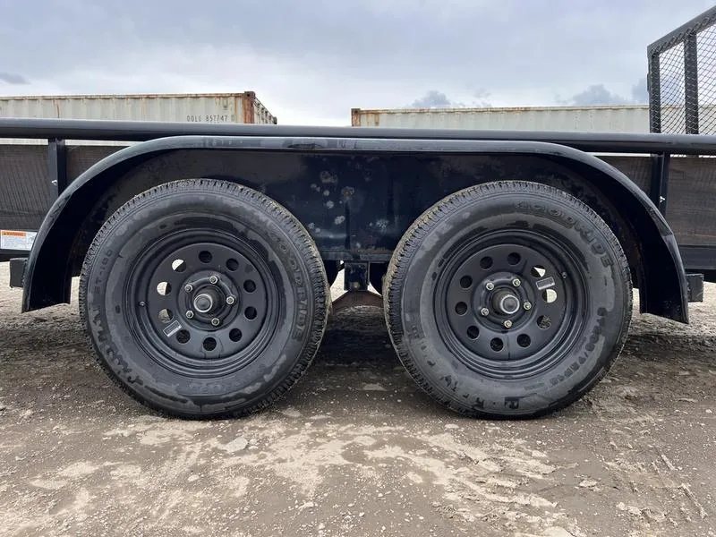 2021 Big Tex 16 ft Utility Trailer – Ramp Gate & Spare – Close-up of the tandem axles and black wheels under the trailer fender
