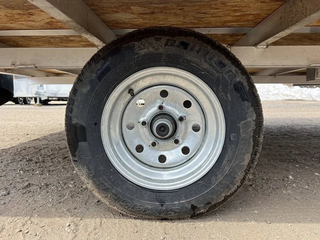 2023 Sno Pro 2-Place Snowmobile Trailer – Galvanized Package – Close up of a single trailer tire and galvanized steel wheel assembly