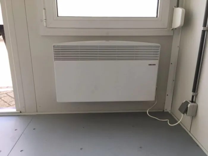 10ft Insulated Accommodation Container – Site Office – wall-mounted electric heater beneath a window inside the unit