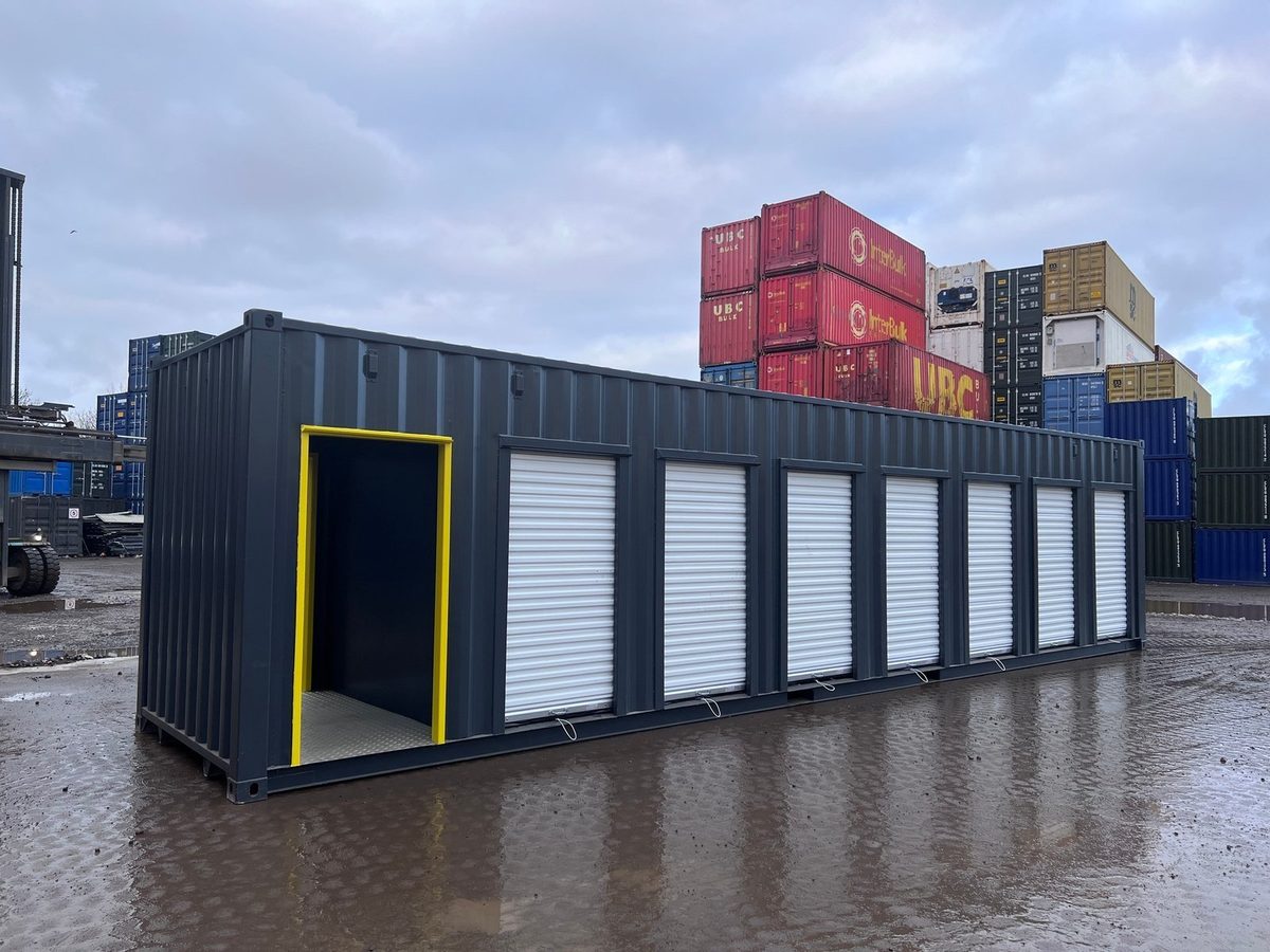 40ft High Cube Storage Container – Seven Lockable Bays – Three-quarter exterior of storage container with seven white roller doors