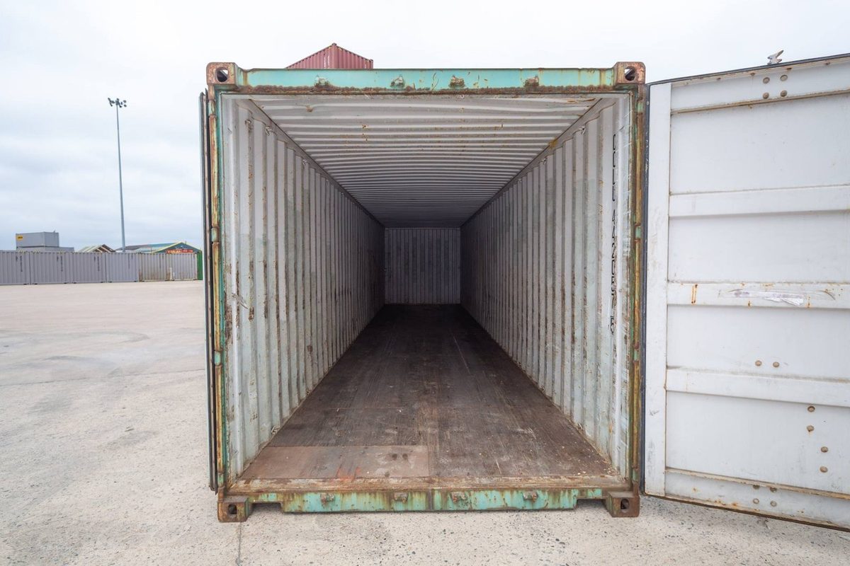 40ft Used Shipping Container – Wind & Watertight Storage – empty container interior with worn wooden floor and open door
