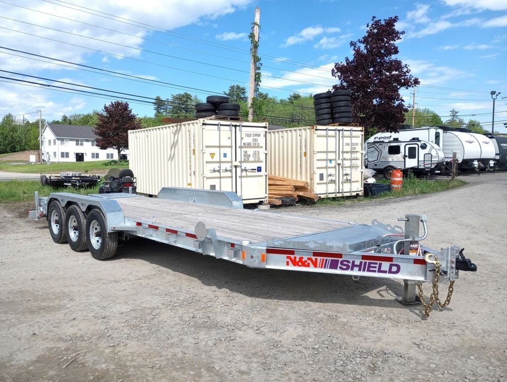 2024 N&N Trailers 20 ft Equipment Trailer – Full-Width Ramps – A three-quarter front view of a galvanized triple axle equipment trailer parked on gravel