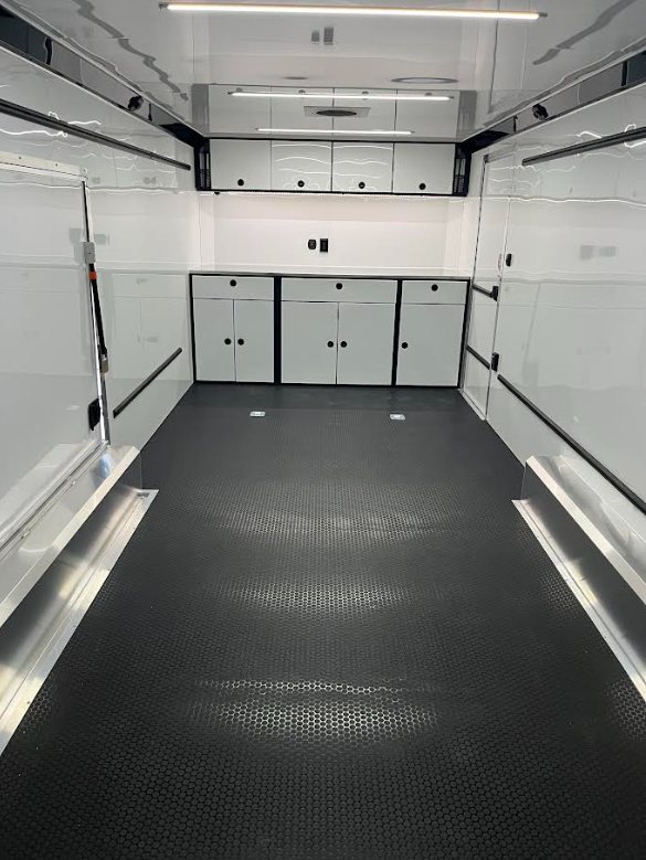 2026 ATC 24 ft ROM 550 Car Trailer – Silverfrost – Interior view looking toward front white cabinets and workspace area with lighting