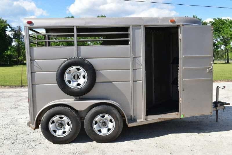 2010 Calico 2 Horse Trailer – Steel, Walk-In Dressing Room – Full side profile view showing the spare tire and an open side entry door