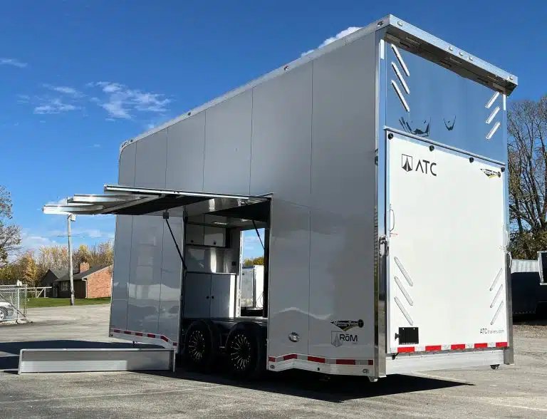 2026 ATC 22 ft Stacker – 14 ft Lift – White enclosed stacker trailer with the side escape door and awning open