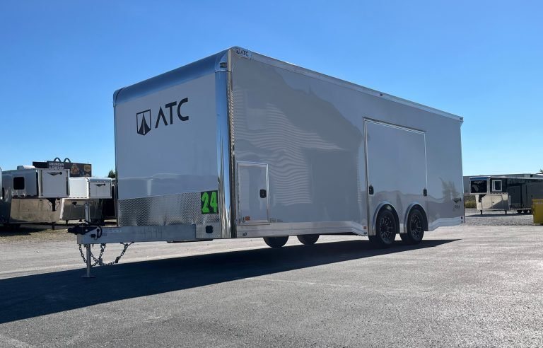 2026 ATC 24 ft ROM 550 – Lithium Power – Front three-quarter view of a white enclosed car trailer against a clear sky