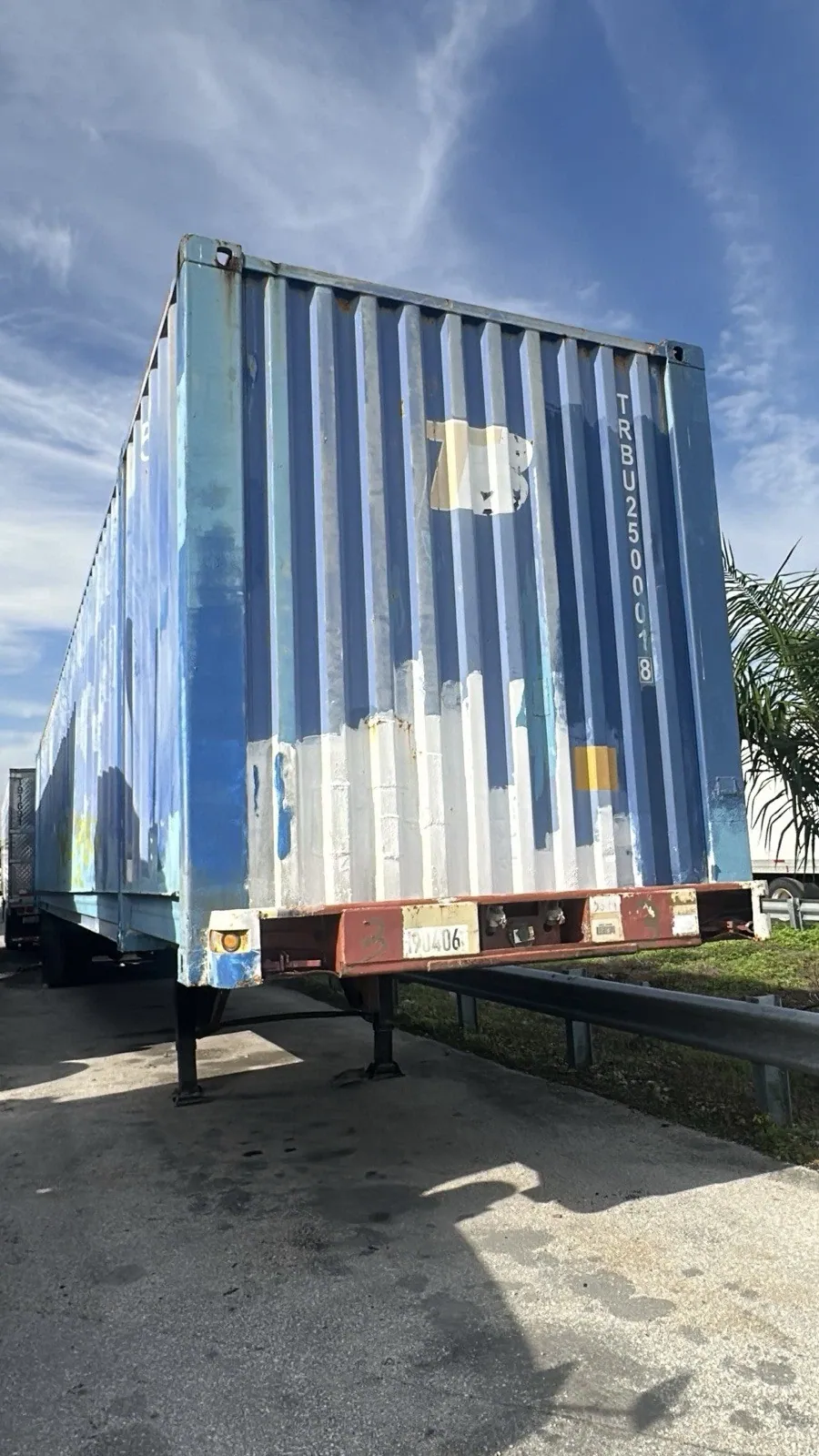 53ft High Cube Shipping Container – Used, Cargo Worthy – weathered blue container on chassis viewed from closed end