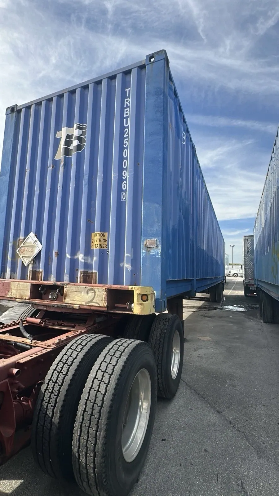 53ft High Cube Shipping Container – Used, Cargo Worthy – blue shipping container on chassis beside parked trailers