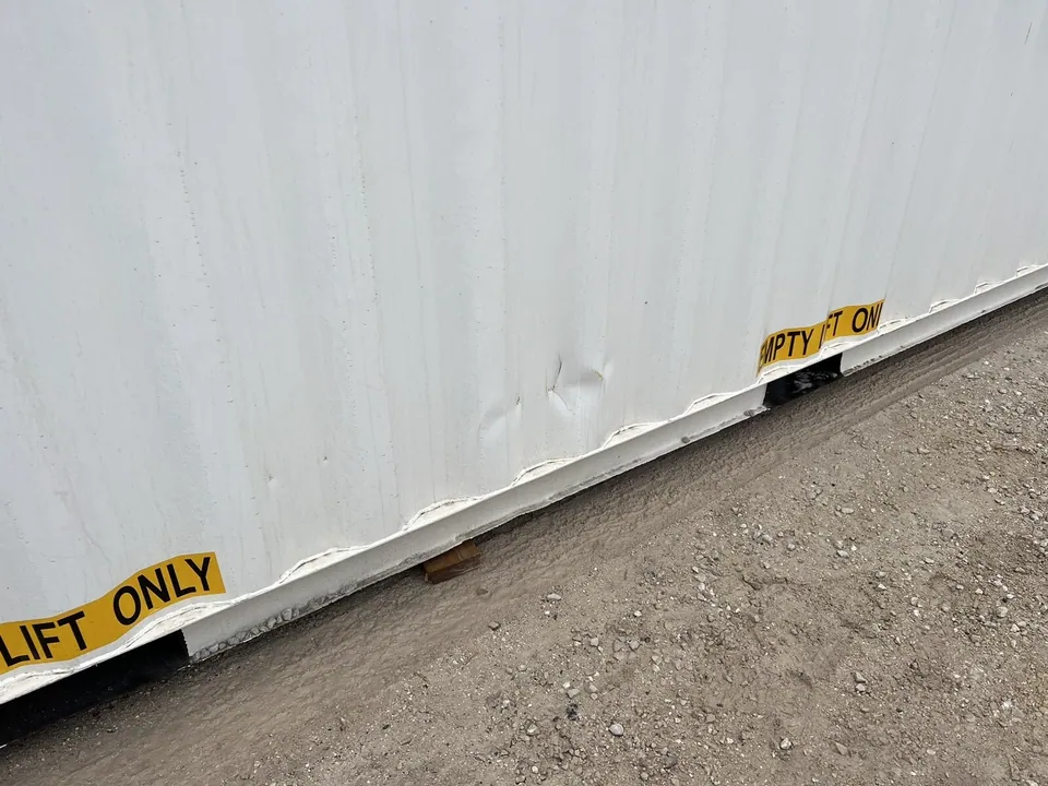 40ft High Cube Shipping Container – One-Trip, Double Doors – close-up of dented lower container wall with lifting labels