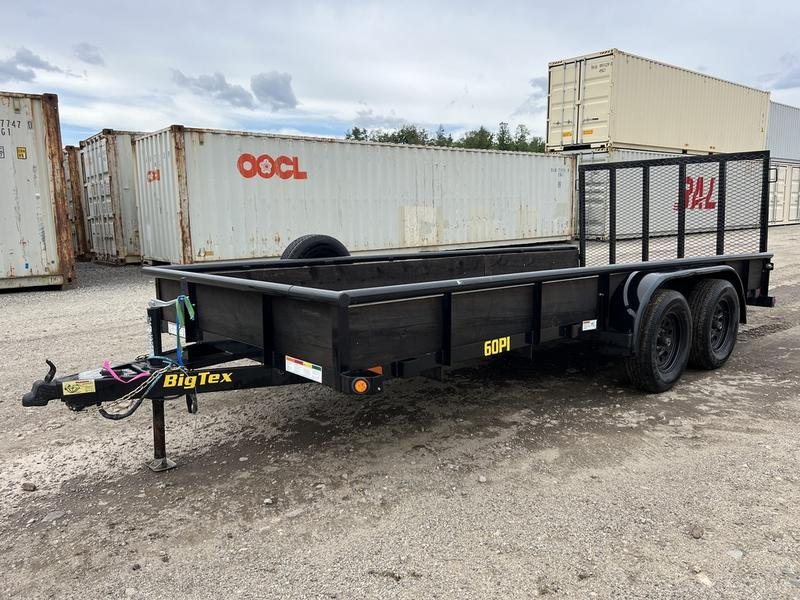 2021 Big Tex 16 ft Utility Trailer – Ramp Gate & Spare – Side profile of the black utility trailer with shipping containers in the background