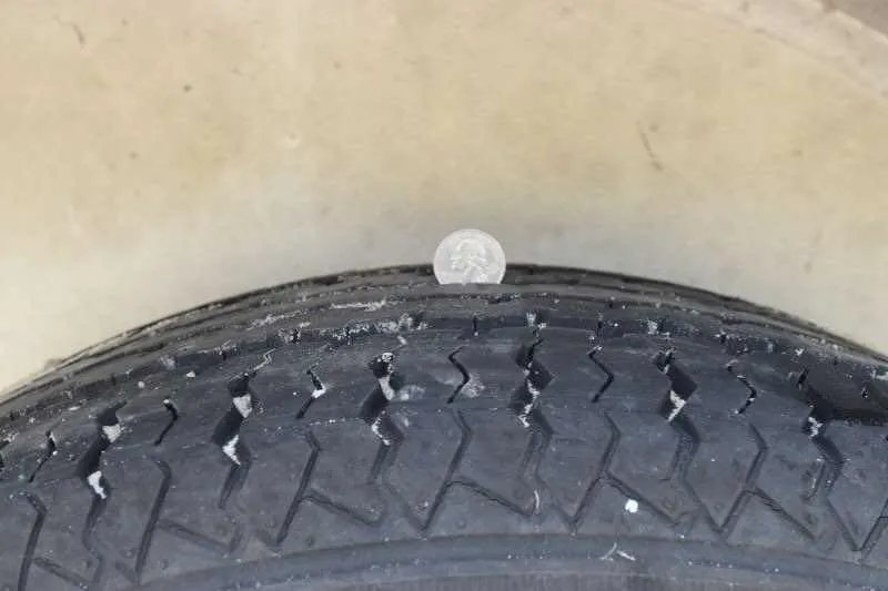 2002 Kiefer Built 2 Horse Bumper Pull – Dressing Room – Close up of tire tread depth measured with a coin