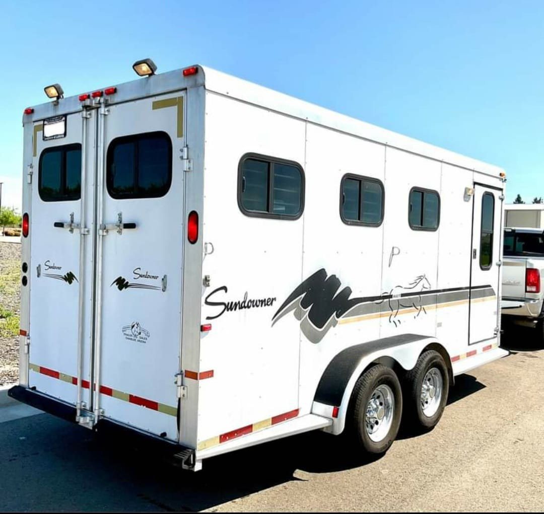 1999 Sundowner 3 Horse Trailer – Removable Rear Tack – Rear three-quarter view of the horse trailer showing wheels and side graphics
