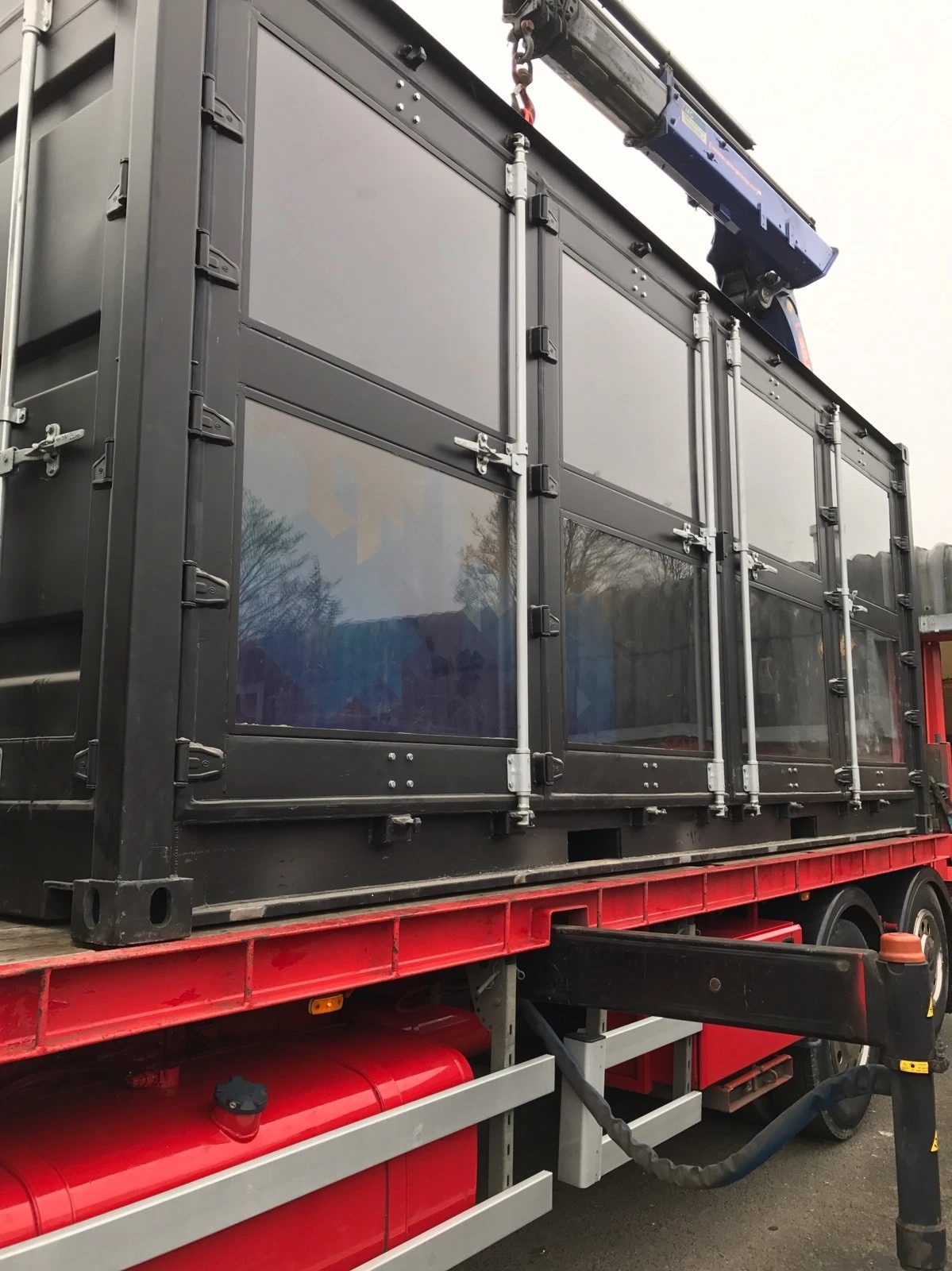 20ft Used Shipping Container – Integrated Glass Windows – dark container with glazed side doors on delivery truck