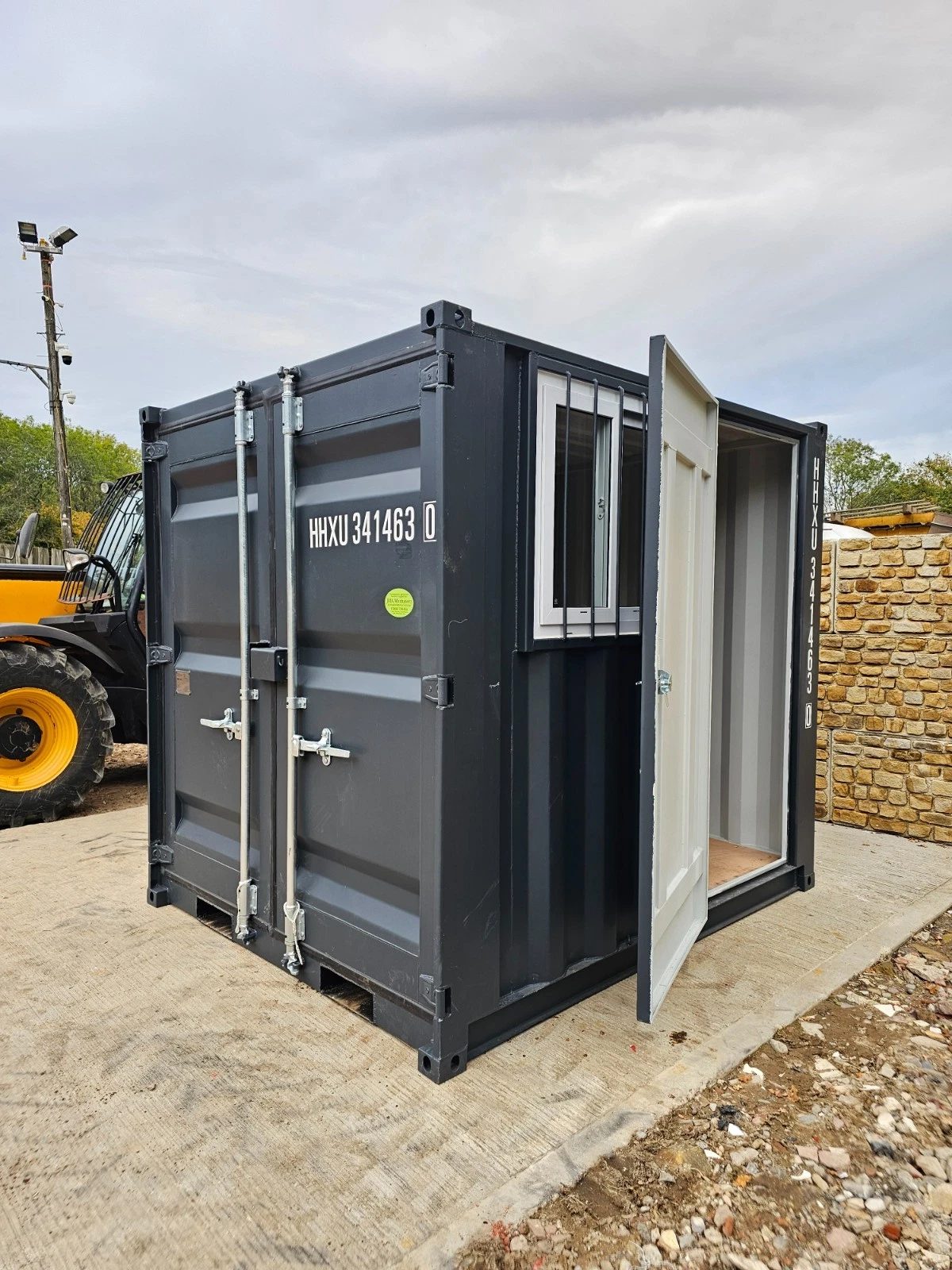 8ft New Shipping Container – Lockbox and Barred Windows – three-quarter exterior with closed cargo doors and open side entrance