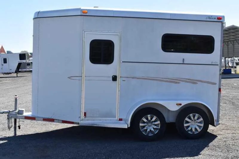 2004 Dalton 2 Horse Bumper Pull Trailer – Aluminum, Straight Load – Side profile view of the trailer focused on the wheels and side door