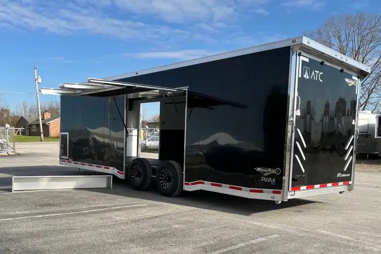 2026 ATC 28 ft Car Trailer – Premier Package – Black enclosed trailer with large escape door open showing interior and step
