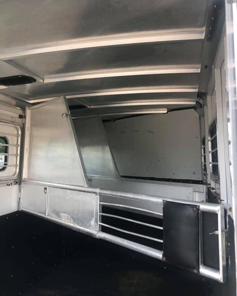 1998 Sundowner 3 Horse Slant Trailer – Dressing Room – Close-up view of the metal horse stall divider with padding