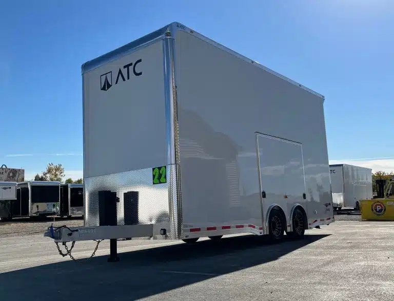 2026 ATC 22 ft Stacker – 14 ft Lift – Front three-quarter view of a white enclosed stacker trailer under a blue sky