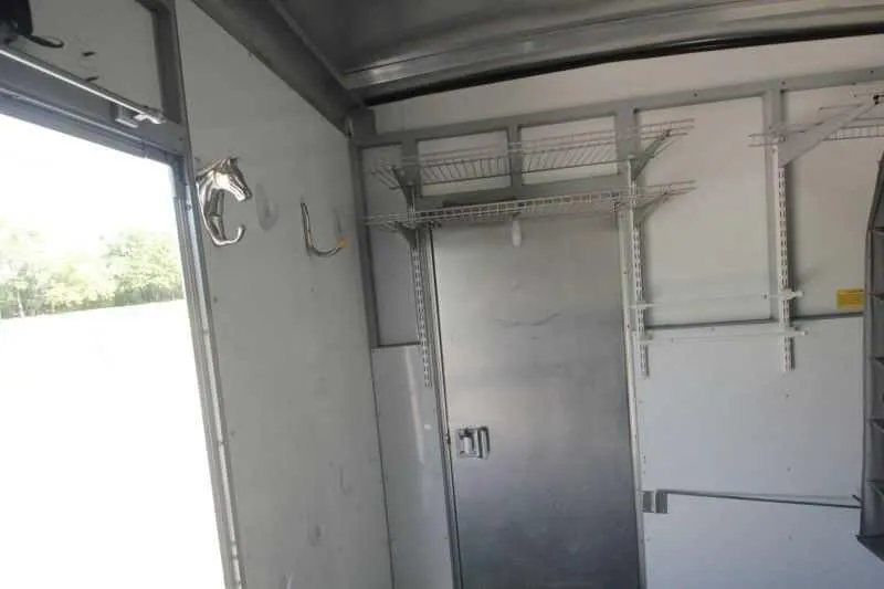 1999 Sundowner 20 ft Horse Trailer – Weekender – Horse head shaped wall hooks and wire shelving inside the tack area