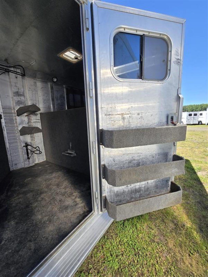 2006 C&C 4 Horse Gooseneck Trailer – Dual Hay Racks – Door of the tack room open showing mounted storage bins on the interior