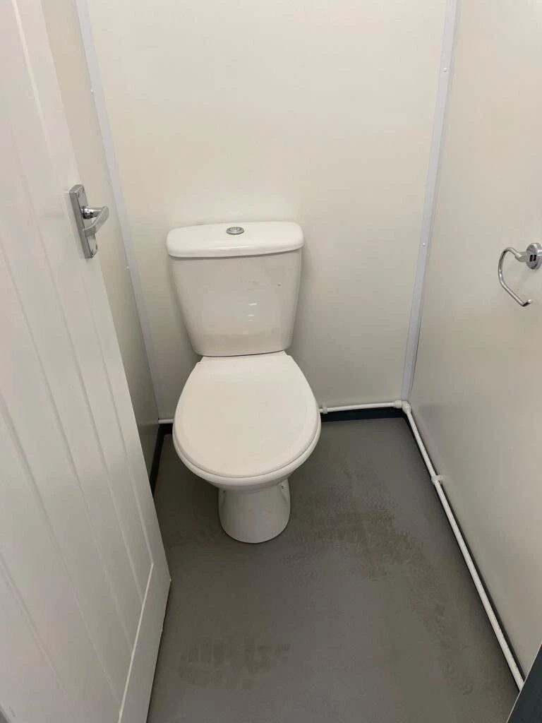 20ft Refurbished Container Toilet Block – Separate Compartments – compact toilet cubicle with white walls and grey floor