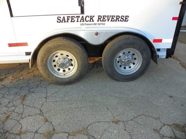 2022 Double D 2 Horse Bumper Pull – Reverse Slant – Close up of tandem axles with silver wheels and black tires
