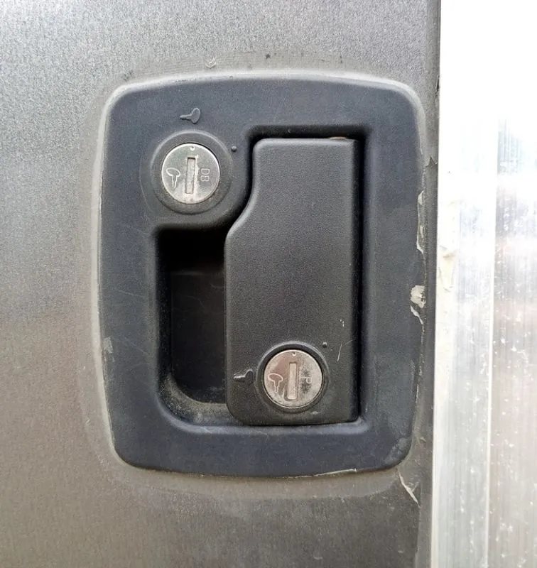 2022 Sno Pro Trailers Hybrid 2.0 – Charcoal Snowmobile Trailer – Close-up of a black recessed trailer door handle with two key locks