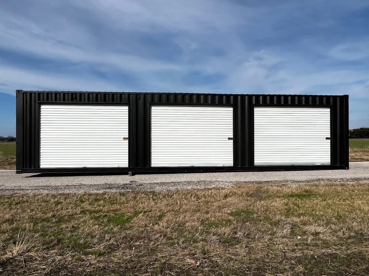 40ft Modified Shipping Container – Three Roll-Up Side Doors – Black shipping container with three closed white roll-up side doors