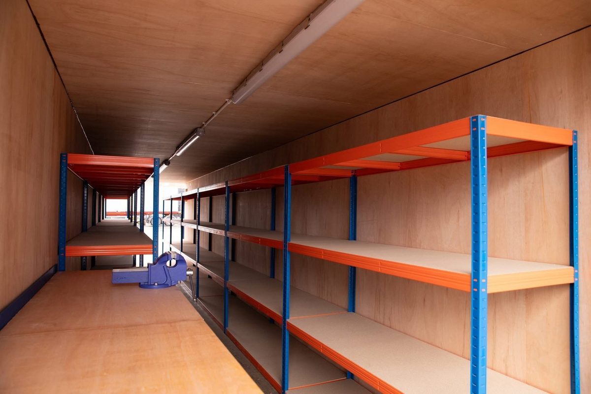 40ft Tunnel Container Workshop – Dual-End Access and Shelving – Plywood-lined workshop interior with shelving, workbench and bench vise
