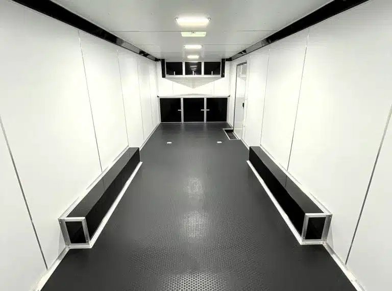 2025 Millennium Blaze 26 ft Car Hauler – Cabinets – Inside view looking toward the front cabinets in a white and black trailer interior