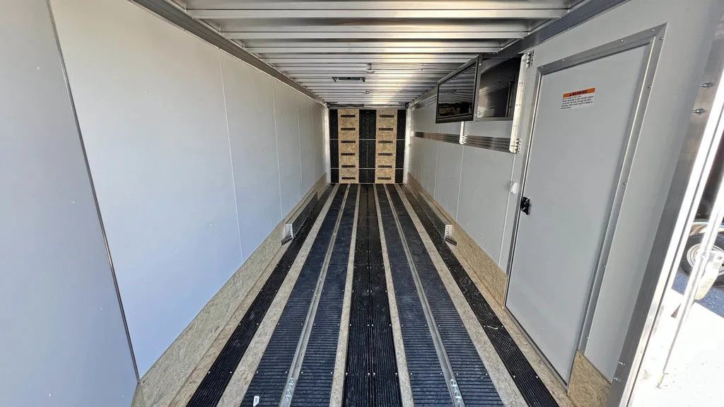 2024 Sno Pro 22 ft Snowmobile Trailer – Extra Height – Full length view of the trailer interior showing the floor guides and white walls