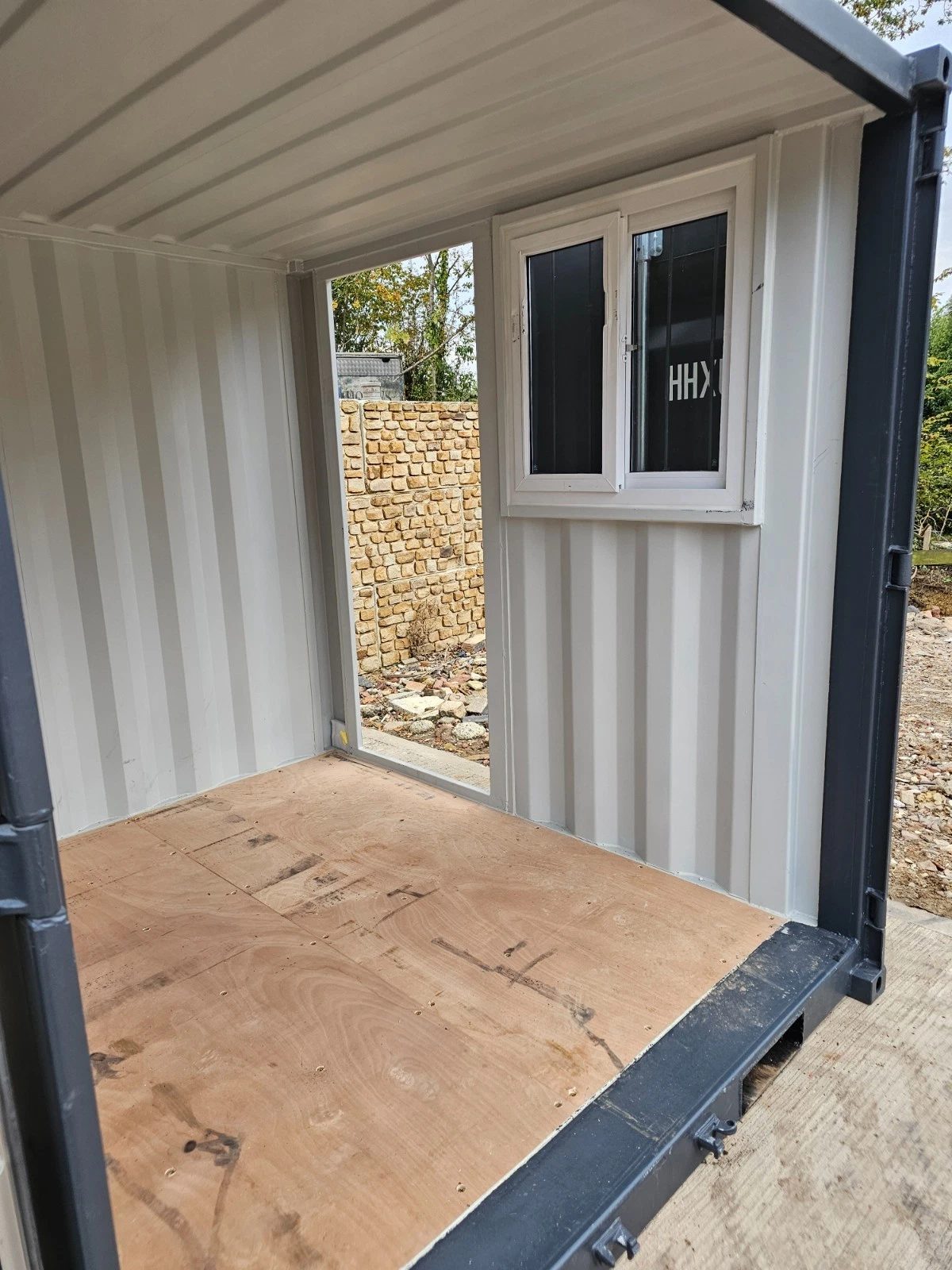 8ft New Shipping Container – Lockbox and Barred Windows – empty container interior with plywood floor and white framed window