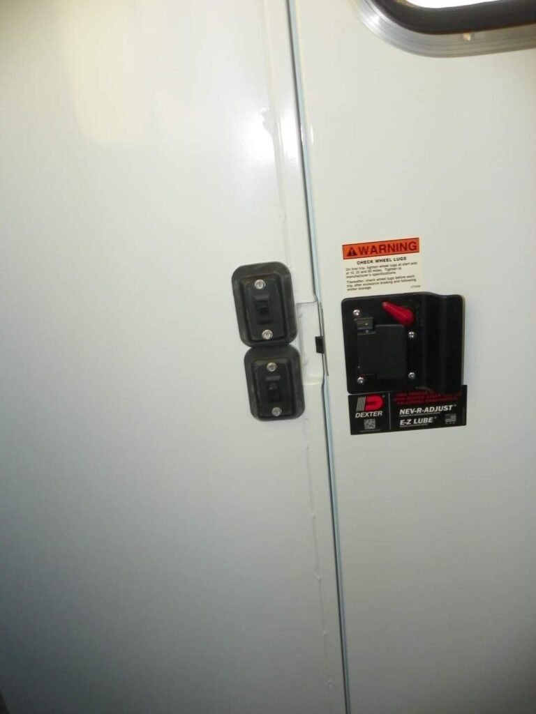 2022 Double D 2 Horse Bumper Pull – Reverse Slant – Close up of door hardware and safety warning stickers on white door