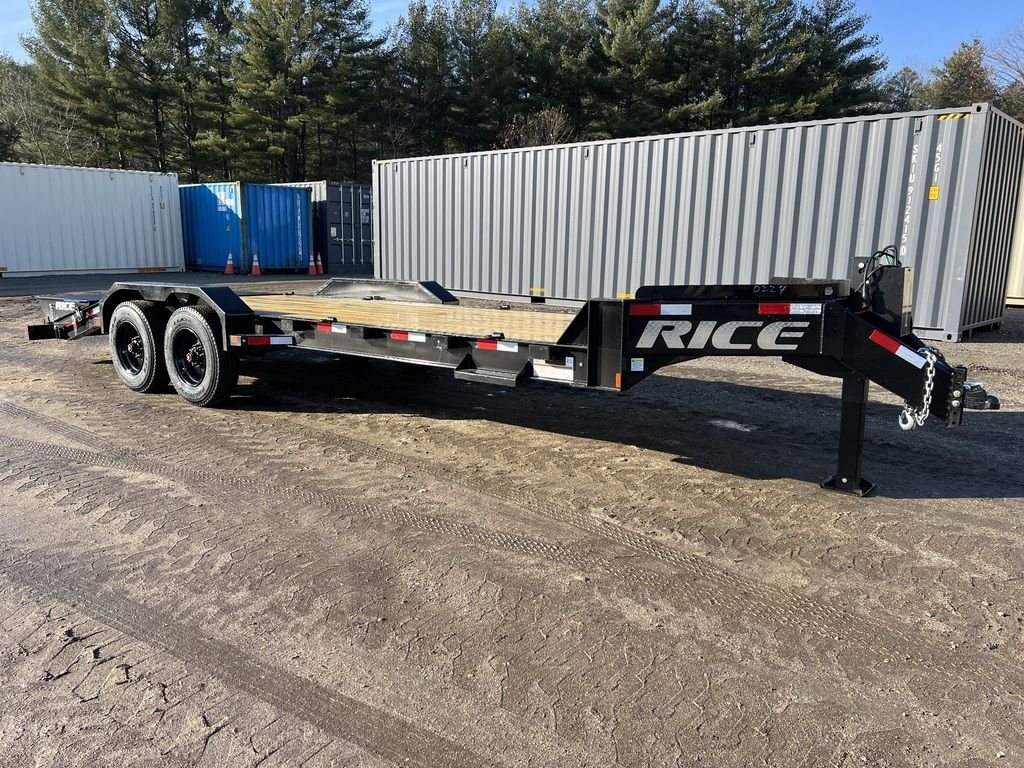 2024 Rice Trailers 18 ft Equipment Trailer – Hydraulic Jack – Full length side view of the black equipment trailer against shipping containers