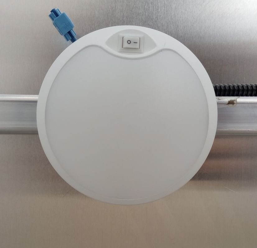 2024 Mission Trailers 24 ft Deckover – Galvanized Package – Close-up of a circular interior LED dome light with integrated power switch