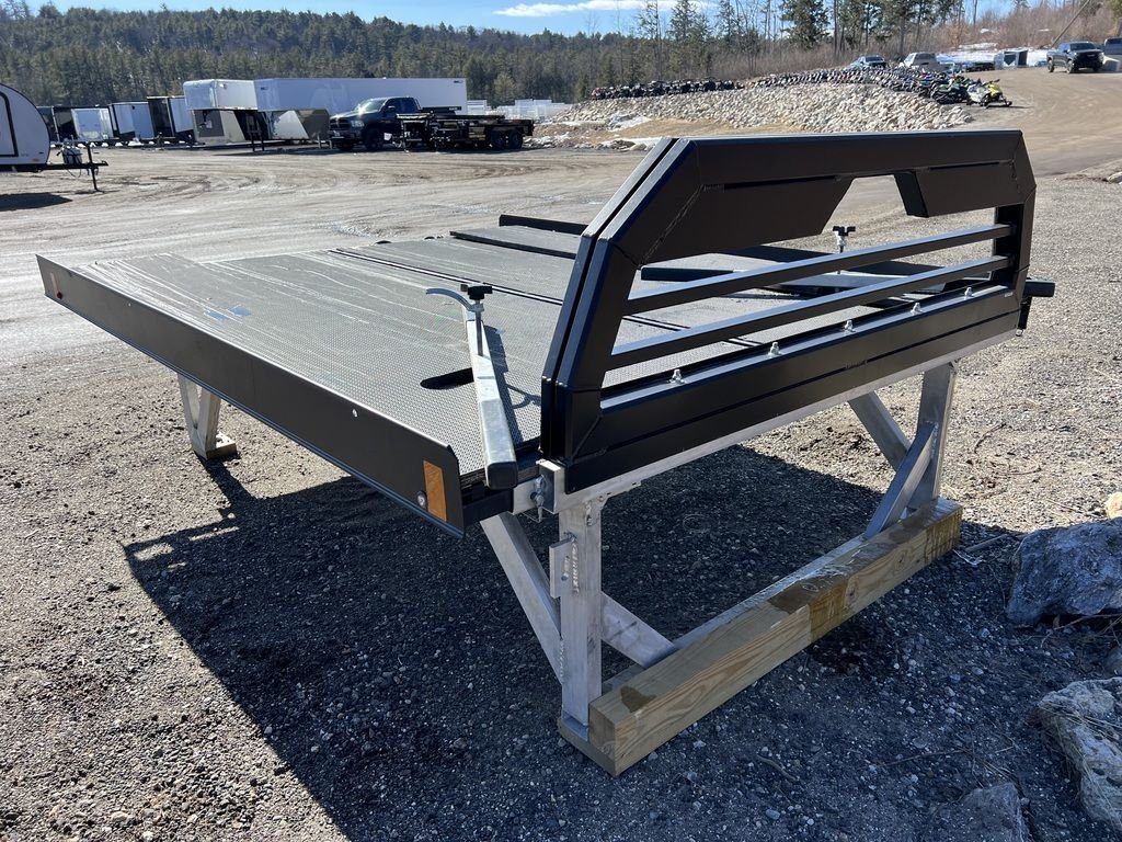2023 Sno Pro 8 ft Sled Deck – Sliding Sides – Front three-quarter view of the black sled deck on its support legs