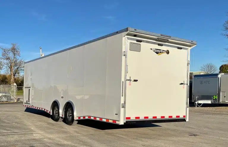 2026 Millennium 28 ft Car Hauler – White – Rear three-quarter view from the driver side showing the ramp door closed