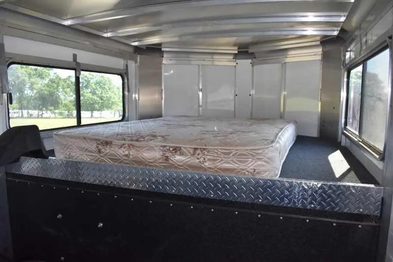 2014 Sundowner 2 Horse Gooseneck Trailer – Electric Jack – Sleeping area in the gooseneck section featuring a mattress and windows