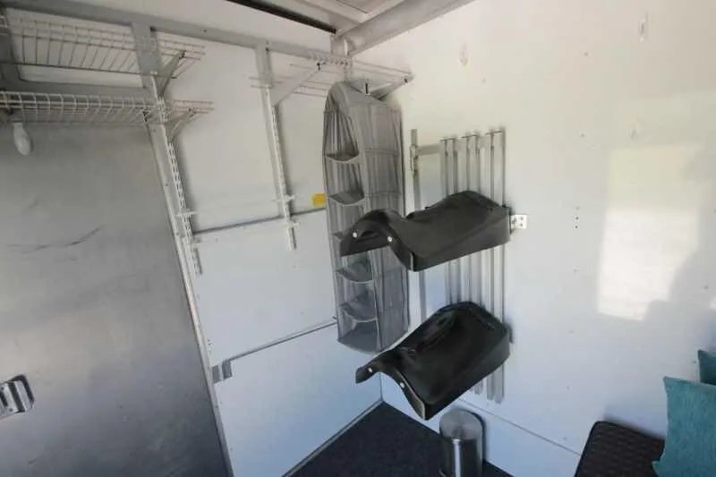 1999 Sundowner 20 ft Horse Trailer – Weekender – Interior tack room area with wire shelving and black saddle racks