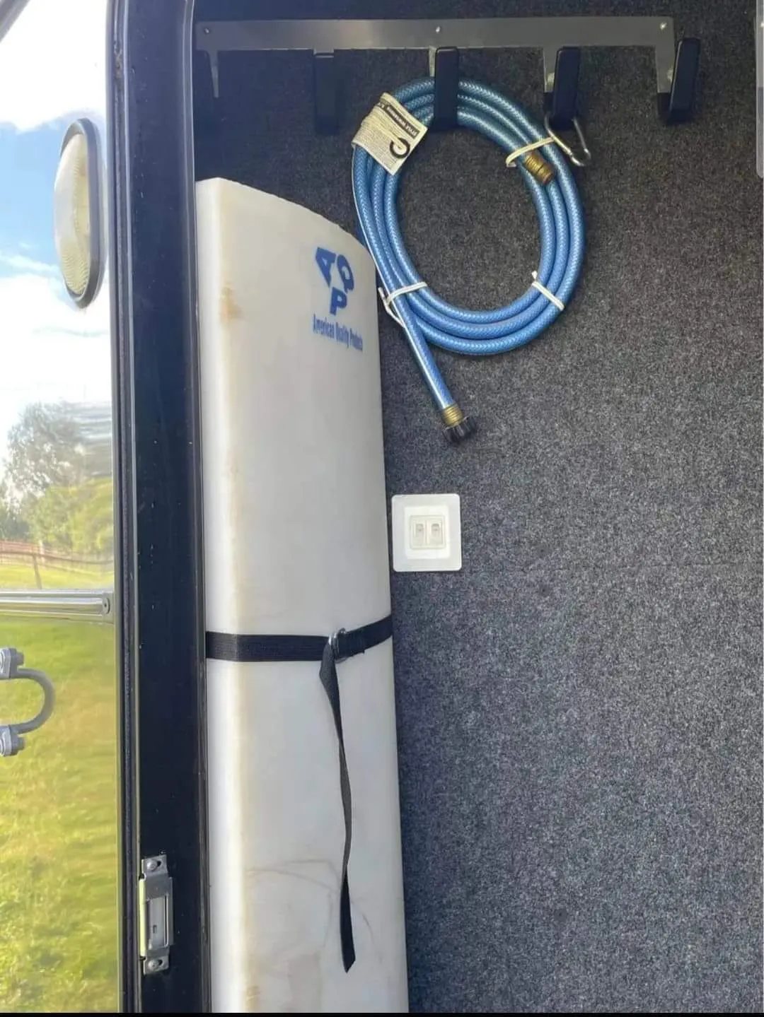 2005 Classic 16 ft 3 Horse Trailer – Dual Tack – Inside the tack room showing a water tank and blue hose on hooks