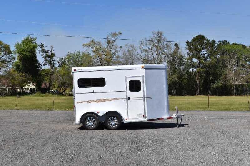 2004 Dalton 2 Horse Bumper Pull Trailer – Aluminum, Straight Load – Full profile side view of the white horse trailer against a treeline background
