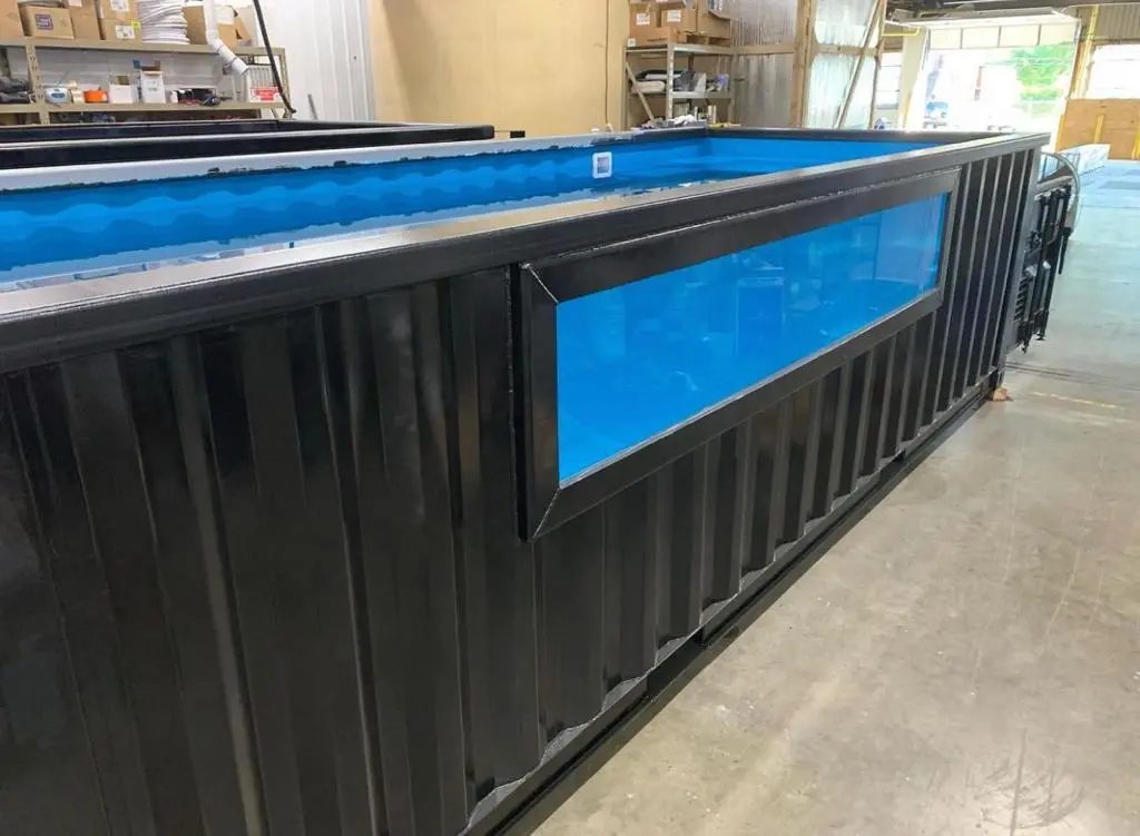 40ft Custom Container Pool – Side Viewing Window – black container pool with blue interior and large side window