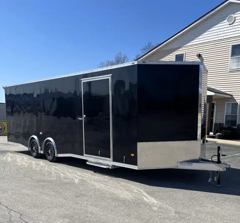 2026 Millennium 26 ft Car Hauler – Black Aluminum – Front three-quarter view of a black enclosed trailer showing side entry door and hitch