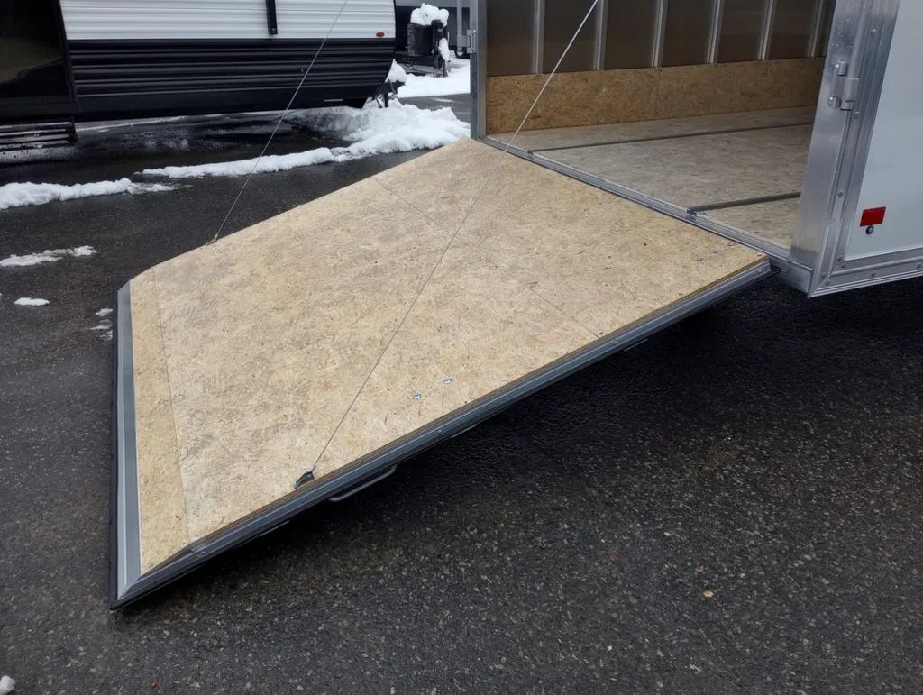 2024 Mission Trailers 12 ft Powersports – Side X Side – The rear ramp door lowered to the ground showing the wood composite surface